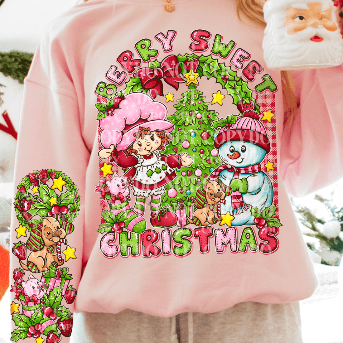 Pink sweatshirt with Christmas-themed design featuring a snowman, girl, and tree.