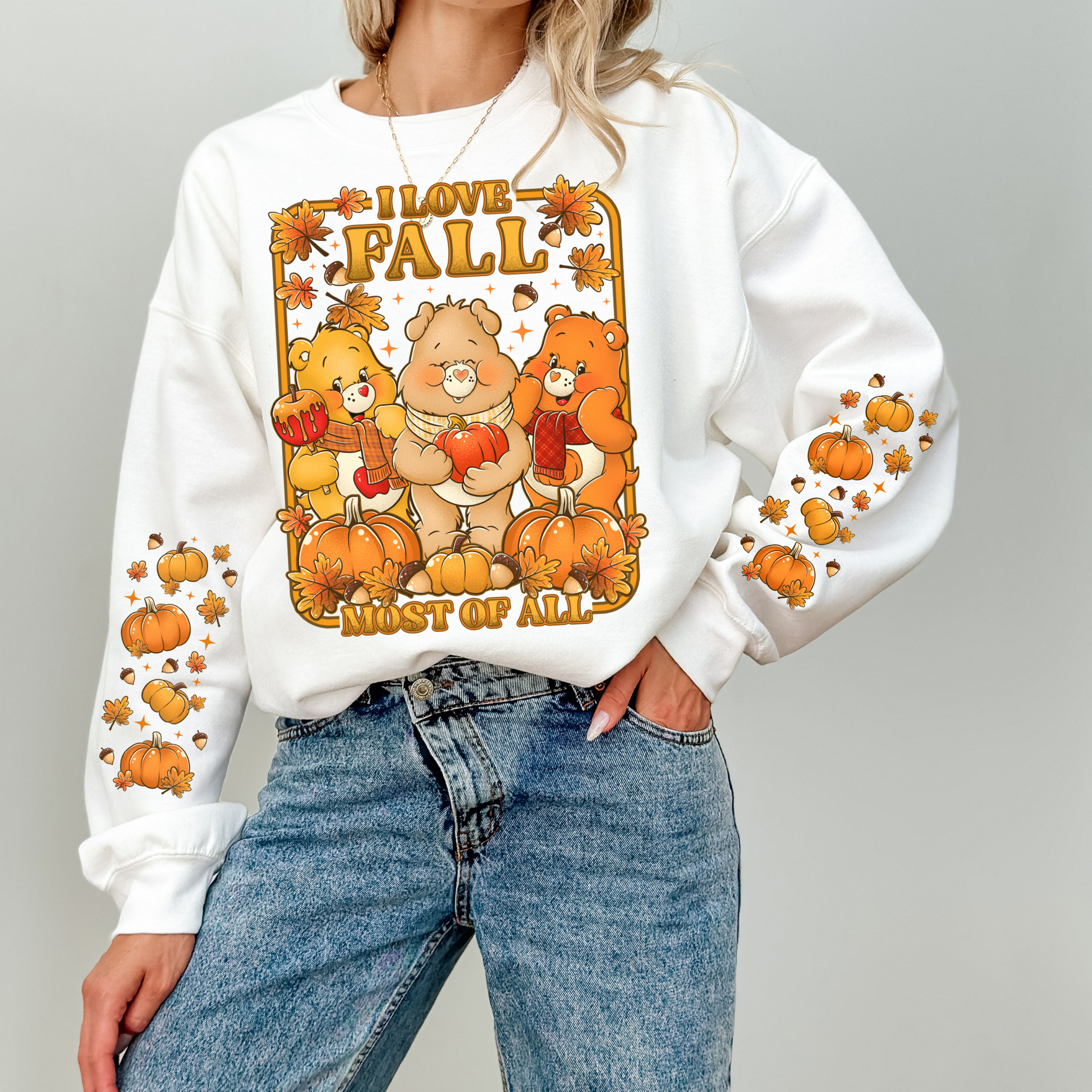 Person wearing a white sweatshirt with autumn-themed design featuring bears and pumpkins. cozy-fall-bear-sweatshirt