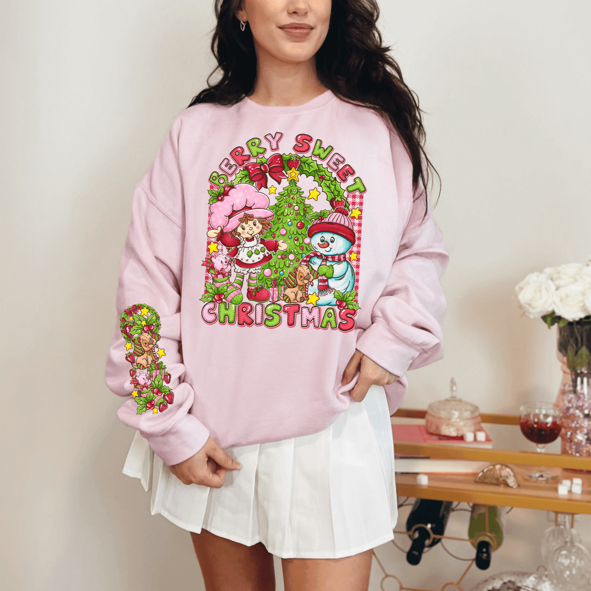 Woman wearing a pink 'Merry Sweet Christmas' sweater with festive design.