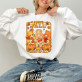 Person wearing a white sweatshirt with 'I love fall most of all' design featuring cartoon bears and pumpkins. cozy-fall-bear-sweatshirt