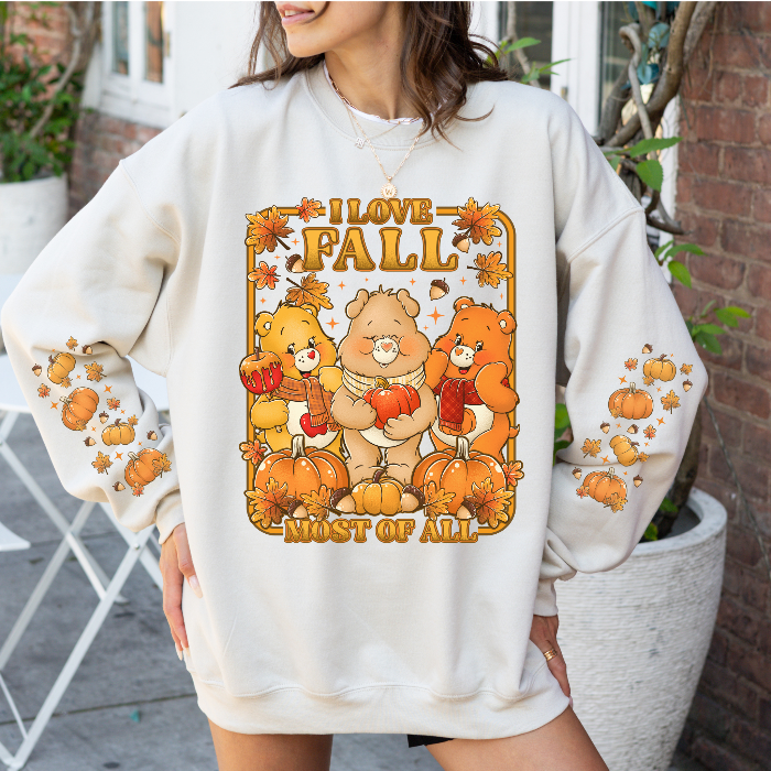 Person wearing a white sweatshirt with 'I Love Fall Most of All' graphic featuring bears and pumpkins.
