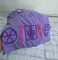 Folded purple t-shirt with embroidered symbols on a textured surface.radiologist-t-shirt