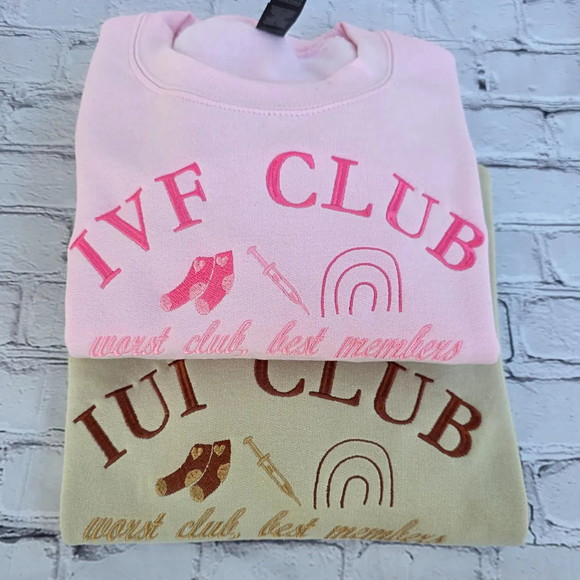 Pink and beige sweatshirt with 'IVF CLUB' text and graphics on a textured white background. ivf-sweatshirt