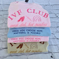 Stack of baby bibs with motivational text and symbols on a textured surface. ivf-sweatshirt