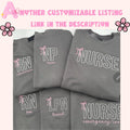 Black sweatshirt with embroidered pink text spelling 'NURSE' and a heart-shaped bow design underneath.